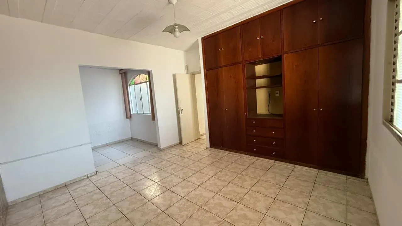 Quarto da Casa do Lourdes com amplo armário embutido de madeira e nicho, piso cerâmico e boa iluminação