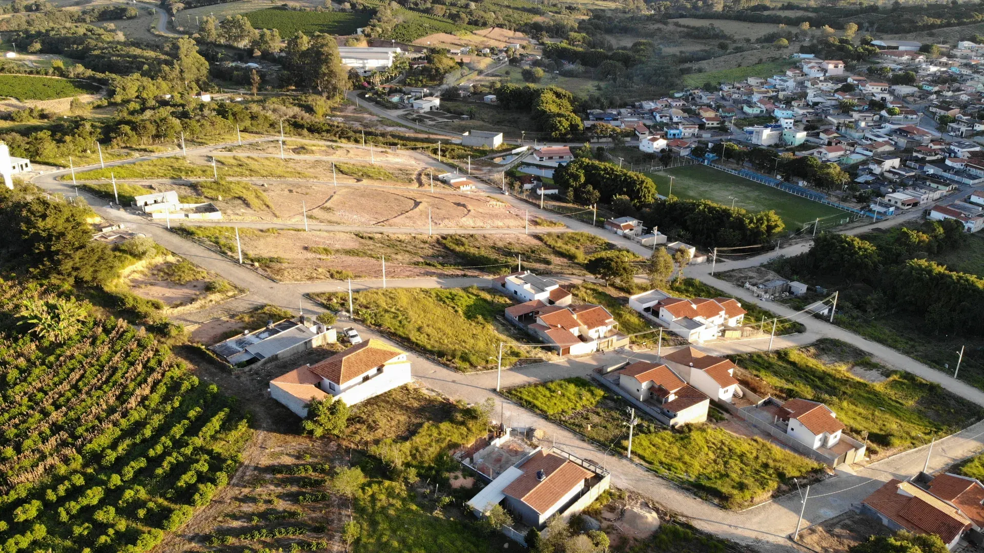 Aérea do Residencial Bela Vista com lotes demarcados, ruas em formação e primeiras casas construídas no extremo do loteamento