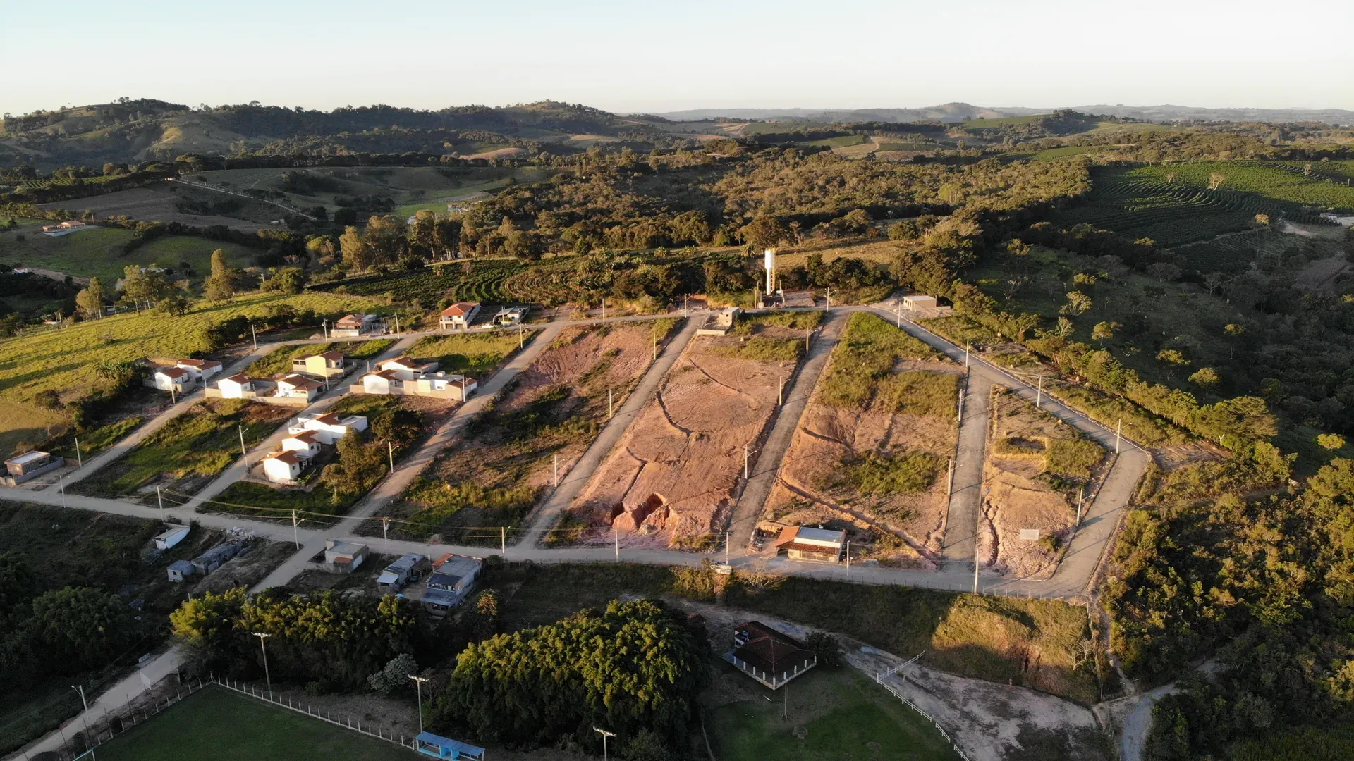 Perspectiva aérea do conjunto do Residencial Bela Vista com as quadras já formadas, integradas à mata e à vizinhança existente