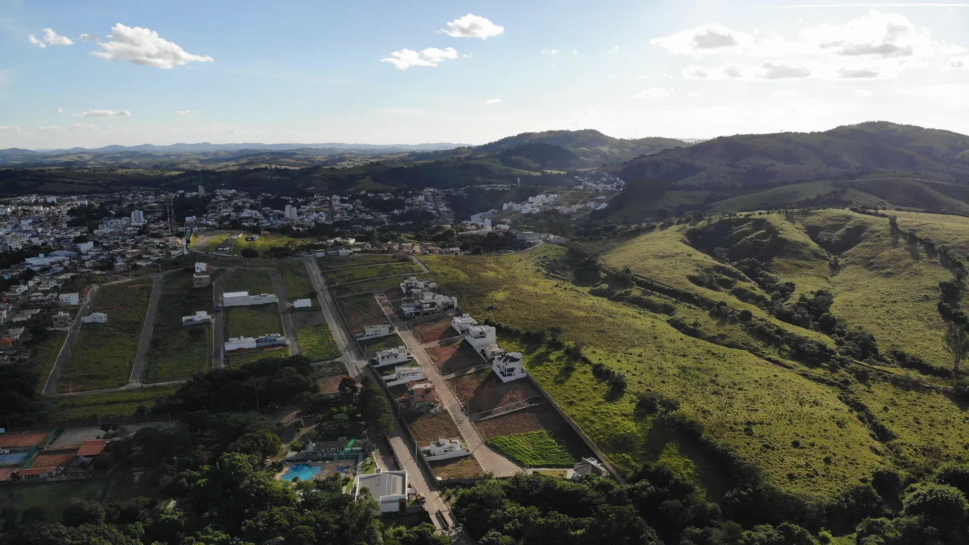 Aérea do Gran Ville com lotes, casas residenciais e Clube Campestre vizinho à esquerda, sob serra à direita