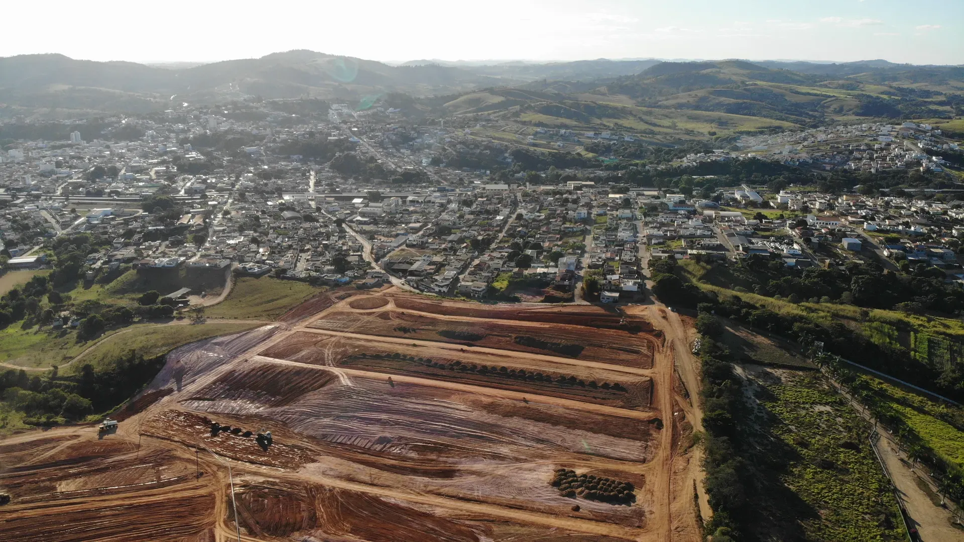 Aérea do Portal da Serra em terraplenagem, com a cidade de Perdões e as colinas da serra ao fundo