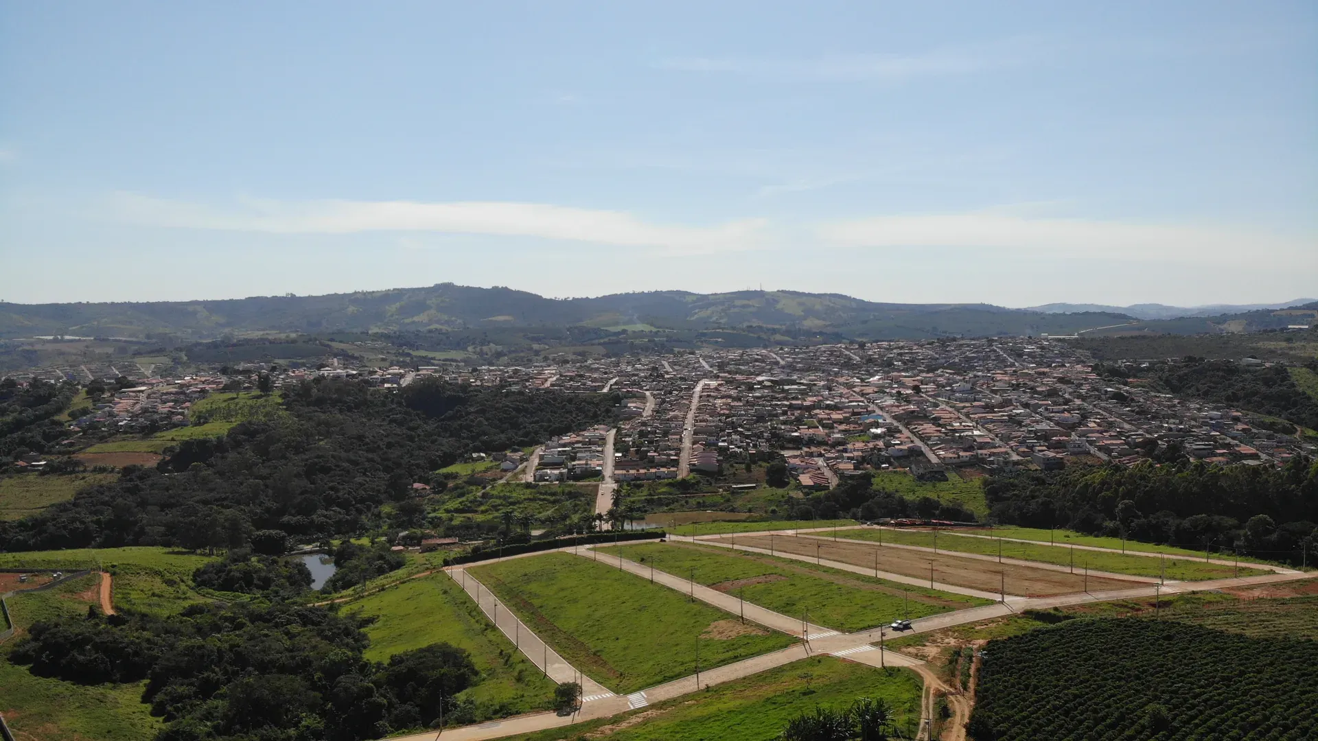 Vista aérea panorâmica do Jardim Natália com as colinas e a serra do Sul de Minas ao fundo