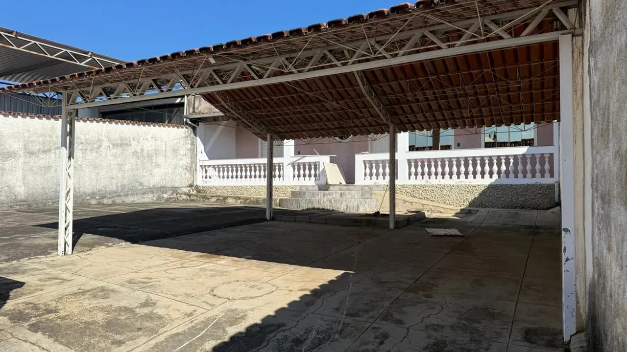 Ampla área coberta da Casa do Lourdes, com piso de concreto e estrutura metálica com telhado