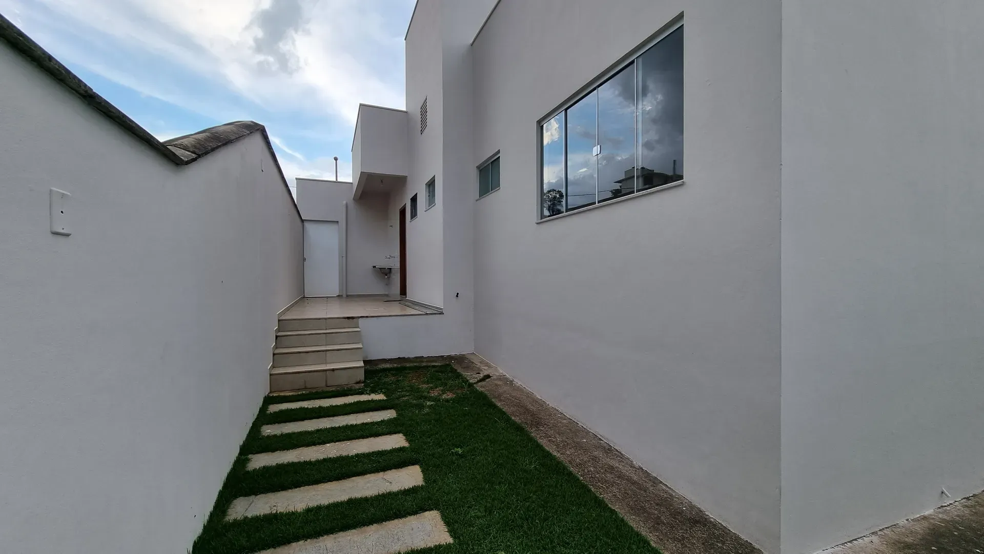 Área externa lateral da Casa do Gran Ville, com tanque, escada de acesso e jardim