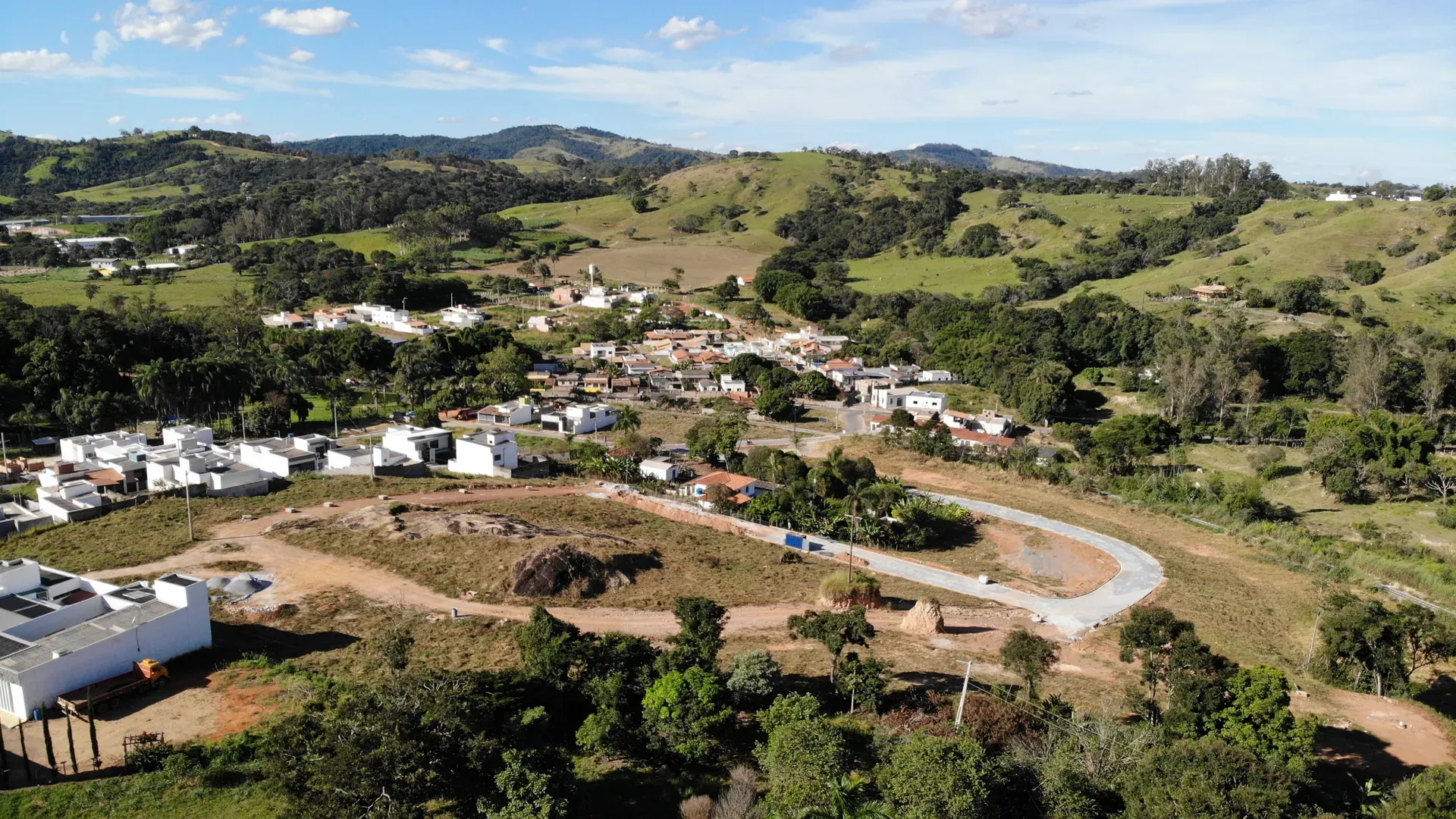 Vista aérea do Residencial Eldorado II em Perdões/MG, com o loteamento e sua via em curva entre o bairro existente e as colinas do Sul de Minas