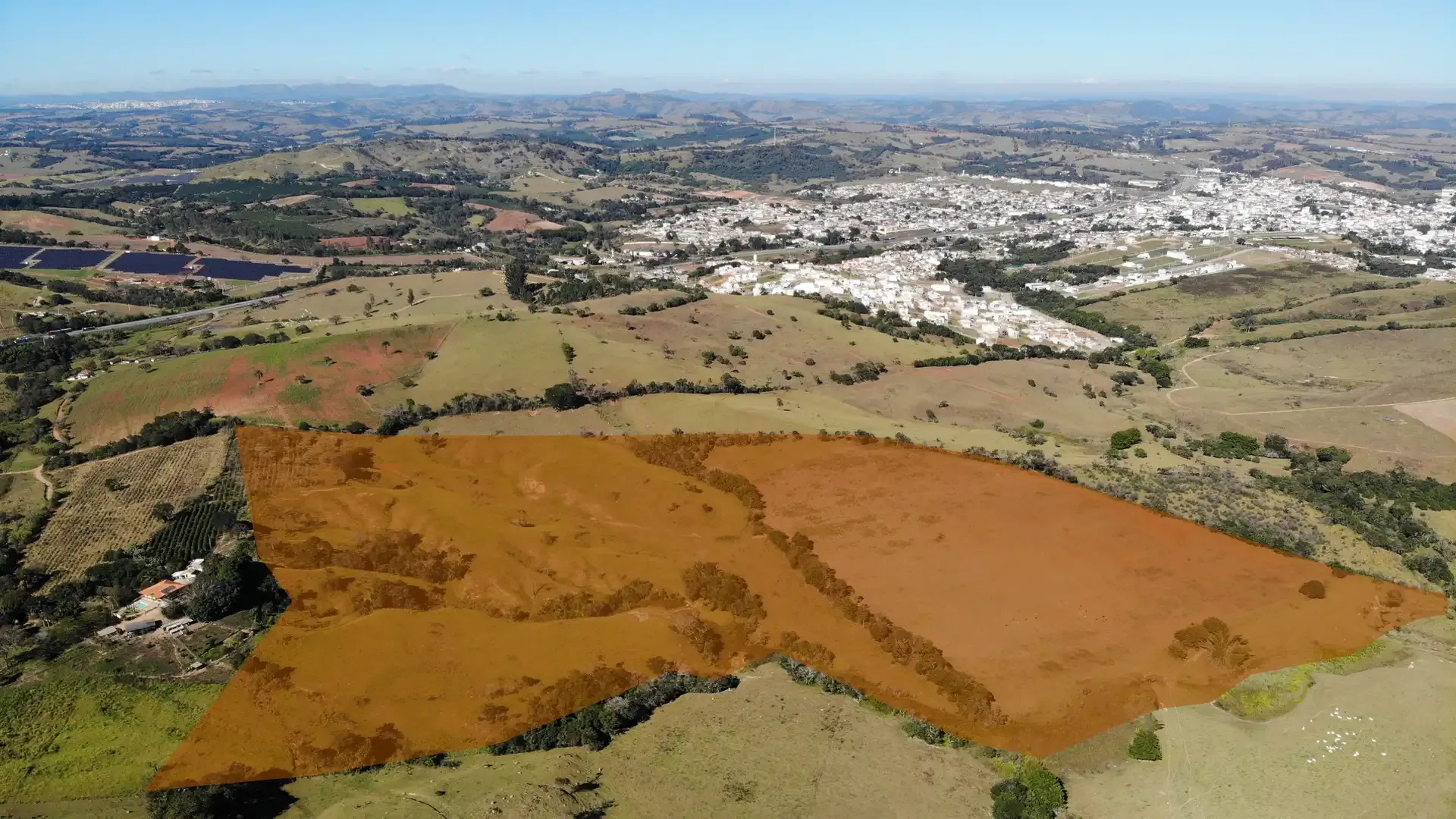 Vista aérea da Fazenda Cachoeirinha, em Perdões/MG, com a área da propriedade demarcada em meio a pastagens e a cidade de Perdões ao fundo