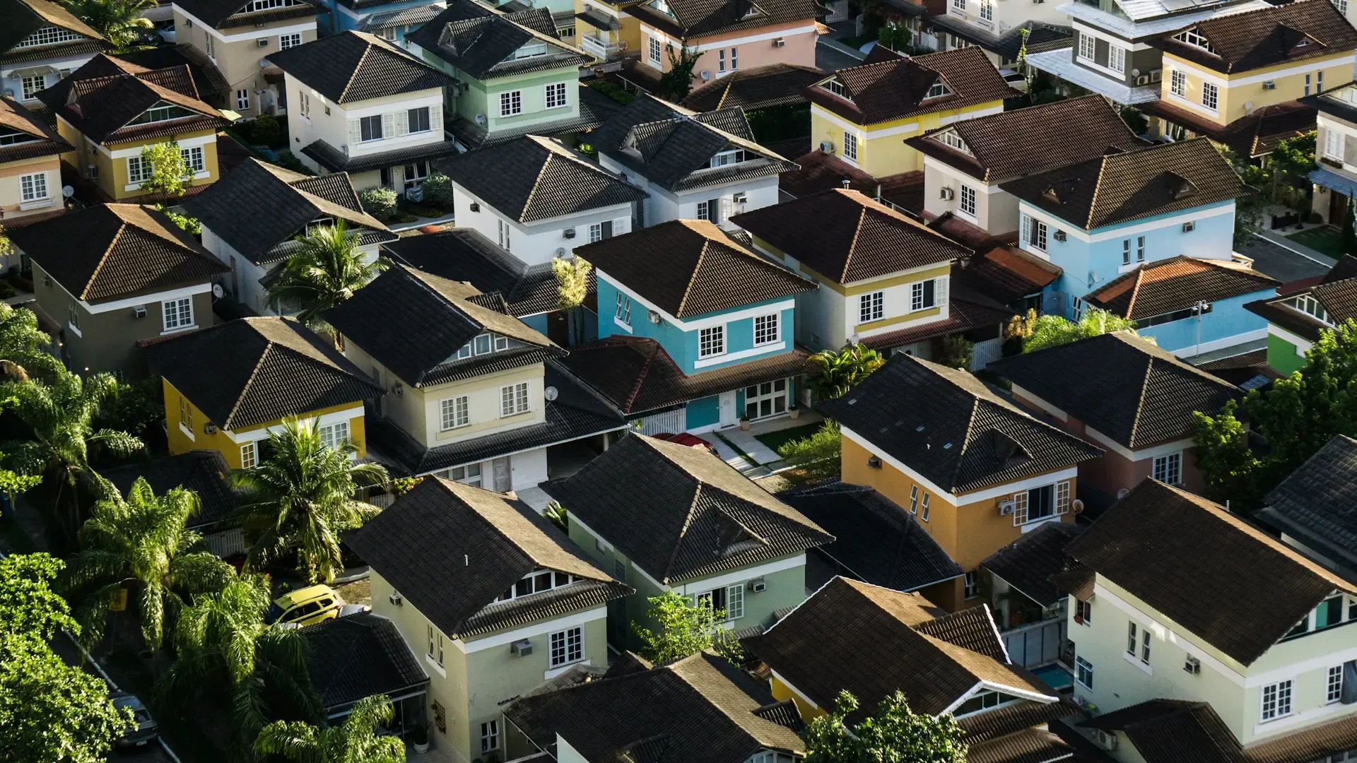 Vista aérea de casas com telhados coloridos em um bairro residencial brasileiro, com lotes e ruas bem demarcados
